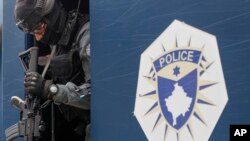 FILE - A Kosovo police officer guards a municipal building after recent violent clashes between police and ethnic Serbs, in the town of Zvecan, northern Kosovo, May 28, 2023.