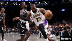 LeBron James (23) de des Los Angeles Lakers dribble Dennis Schroder (17) de Brooklyn, USA, le 31 mars 2024.