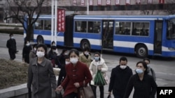 FILE - People walk along a street near the Arch of Triumph in Pyongyang, North Korea, March 25, 2024.