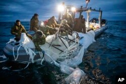 FILE - In this photo provided by the U.S. Navy, sailors assigned to Explosive Ordnance Disposal Group 2 recover a high-altitude surveillance balloon off the coast of Myrtle Beach, S.C., Feb. 5, 2023. A missile fired on Feb. 5 by a U.S. F-22 off the Carolina coast ended the days-long flight of what the Biden administration says was a surveillance operation that took the Chinese balloon near U.S. military sites. It was an unprecedented incursion across U.S. territory for recent decades, and raised concerns among Americans about a possible escalation in spying and other challenges from rival China. (U.S. Navy via AP)