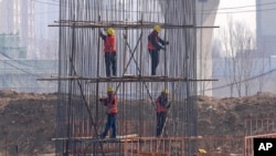 Workers construct a steel structure as they build a column at a flyover construction site at Xiongan in northern China's Hebei province on March 14, 2024.