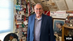 Džonatan Salant stoji ispred stotina pres propusnica koje je sakupio tokom svojih decenija izveštavanja iz Vašingtona. (Foto: VOA/Liam Scott)