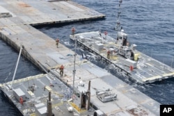 ภาพจากกองทัพบกสหรัฐฯ เผยให้เห็นทหารจากกองพันขนส่งที่ 7 และลูกเรือขนส่ง MV Roy P. Benavidez ติดตั้งท่าเรือลอยน้ำ นอกชายฝั่งกาซ่า ในทะเลเมดิเตอร์เรเนียน เมื่อ 26 เม.ย. 2024 (U.S. Army via AP)