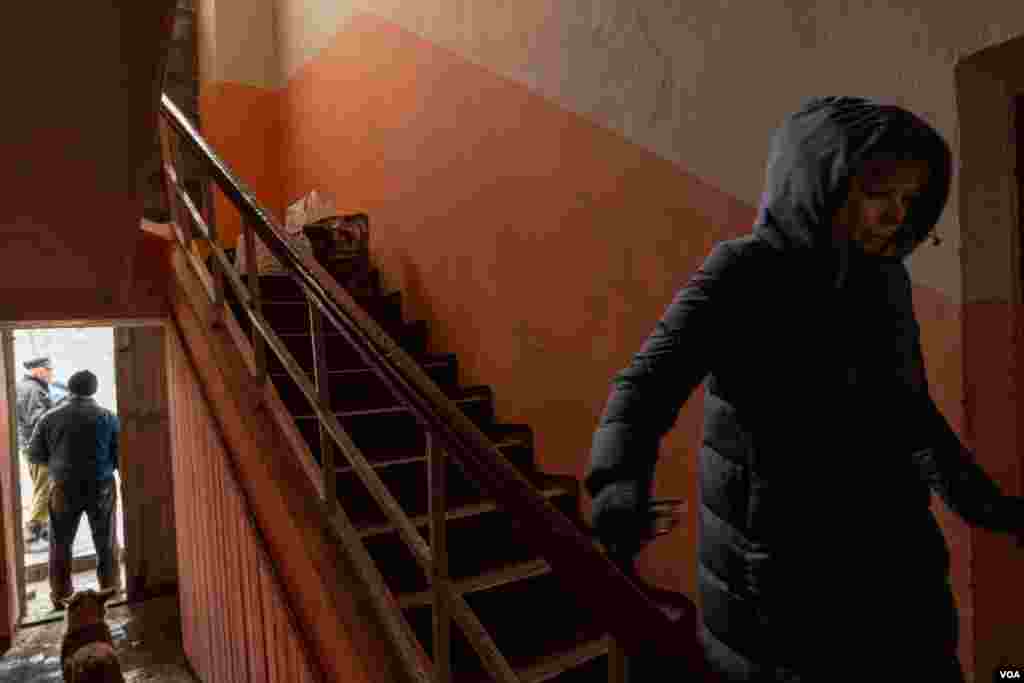A woman walks down the stairs at the only place where residents of Chasiv Yar can get food, internet connection and electricity, on April 3, 2023. (Yan Boechat/VOA) 