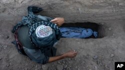 An Afghan man buries his grandson who was killed by the earthquake in the Zindajan district of the Herat province of Afghanistan, Oct. 9, 2023. The earthquake, which struck two days earlier, killed and injured thousands.