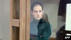 FILE - This image provided by the Moscow City Court on Dec. 14, 2023, shows U.S. journalist Evan Gershkovich standing inside a defendants' cage during a court hearing in Moscow.