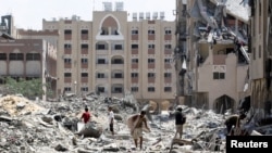 Orang-orang Palestina memeriksa kerusakan di Kota Hamad menyusul serangan Israel di Khan Younis, di selatan Jalur Gaza, Sabtu, 24 Agustus 2024. (Foto: Hatem Khaled/Reuters)