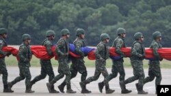 ទាហាន​តៃវ៉ាន់​រត់​កាន់​ទង់ជាតិ​នៅ​ក្នុង​សមយុទ្ធ​យោធា​មួយ​នៅ​តំបន់ Hsinchu ភាគខាងជើង​តៃវ៉ាន់​ កាលពីថ្ងៃទី​២១ កញ្ញា ឆ្នាំ២០២៣។(AP Photo/Chiang Ying-ying)