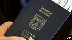 FILE - A woman holds her boarding pass in her passport after checking in for her flight at Newark Liberty International Airport, July 24, 2014, in Newark, NJ. 