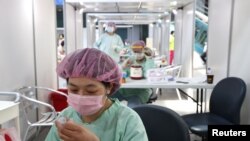 FILE - A worker prepares a dose of vaccine against COVID-19 at the National Taiwan Science Education Center in Taipei City, Taiwan, July 3, 2021. Taiwan, which seeks to expand its source of labor, is taking steps to recruit workers from India, which has high unemployment.