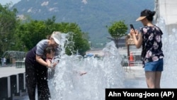 한국 서울의 시민들이 바닥 분수에서 더위를 식히고 있다. (자료사진) 