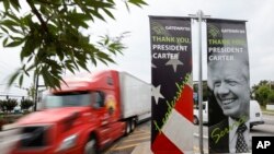 Sejumlah kendaraan bergerak melewati spanduk yang berisi penghargaan terhadap mantan Presiden AS Jimmy Carter yang dipasang di jalan raya Jimmy Carter di Norcross, Georgia, pada 23 Mei 2023. (Foto: AP/Alex Slitz)