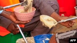 Volunteers prepare food for internally displaced Muslim devotees for their breaking fast meal during the Islamic holy month of Ramadan in Gedaref on March 13, 2024.