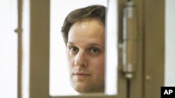 FILE - Wall Street Journal reporter Evan Gershkovich stands in a glass cage in a courtroom at the Moscow City Court in Moscow, Russia, June 22, 2023.