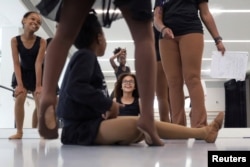 Dior, 10, Maya, 10, Kioni, 10, and Kalani, 8, laugh with Ruth Essel, 30, founder of Pointe Black Ballet School, at the end of class in London, Britain, August 4, 2023. (REUTERS/Alishia Abodunde)