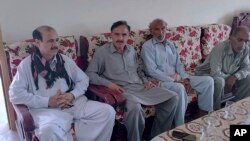 People offer their support to Raja Tariq, left, whose son Raja Awais is missing after a shipwreck off the Greek coast, in Bindian village in Kotli, a district of Pakistan's administrator Kashmir, June 18, 2023. 