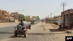 Mwanamume akiendesha gari lake la kukokotwa na punda wakati mapigano yalipopungua. Picha na AFP.