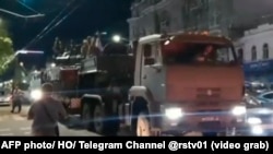 This video grab taken from footage posted June 24, 2023 shows a military vehicle of Wagner Group waiting for Prigozhin to leave the headquarters of the Russian southern military district in Rostov-on-Don as pedestrians film and salute him.