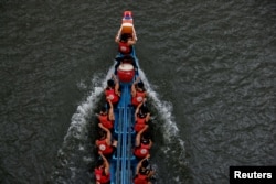 Participants compete in a dragon boat during the annual Dragon Boat Festival in Taipei, Taiwan, June 22, 2023.