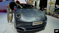 FILE - A worker wipes an Ora, a Chinese electric car, during Auto Shanghai 2023 at a convention center in Shanghai, April 18, 2023. Without compromise by July 4, the European Commission will impose up to 28% increase in customs duties on imports of Chinese electric vehicles.