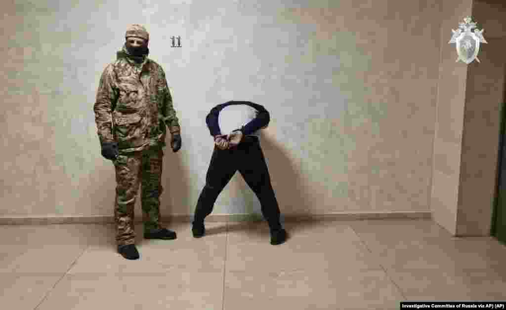In this photo taken from video released by Investigative Committee of Russia on March 24, 2024, a suspect in the Crocus City Hall shooting on Friday, right, stands inside the Russian Investigative Committee headquarters in Moscow, Russia. 