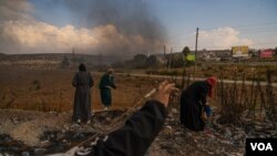 Sejumlah remaja perempuan Palestina tampak mengumpulkan batu untuk dilemparkan ke arah tentara Israel di pinggiran Kota Ramallah di Tepi Barat, pada 18 Oktober 2023. (Foto: VOA/Yan Boechat)