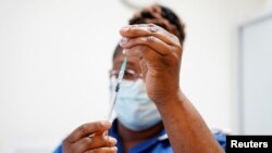 Seorang perawat menyiapkan dosis suntikan vaksin COVID-19 di Rumah Sakit Universitas Coventry, di Coventry, Inggris, pada 22 April 2022. (Foto: Jacob King/Pool via Reuters)