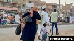 People gather to ride a truck to flee outside Khartoum, during clashes between the paramilitary Rapid Support Forces and the army, in Khartoum, Sudan, April 28, 2023. (Stringer via Reuters)