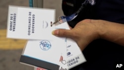 Douglas Guzman shows his press credentials for content creator before filming at Plaza Libertad in San Salvador, El Salvador, Saturday, June 24, 2023. Guzmán and other social media influencers said access to the legislative body was empowering to them.