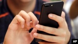 A unidentified person uses a smartphone in Chicago, Sept. 16, 2017. (AP Photo, File)