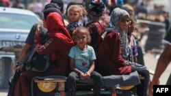 Wapalestina wakiwa wamepanda mkokoteni katika eneo lawatu waliopoteza makazi huko Rafah Juni 19, 2024, Picha na Bashar TALEB / AFP