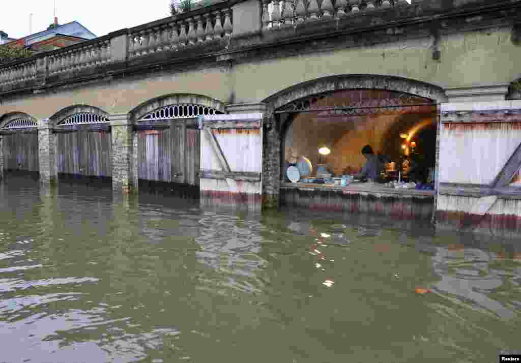 Ceramic artists work in a studio as the River Thames overtops its banks following prolonged rainfall and high tides, in west London.