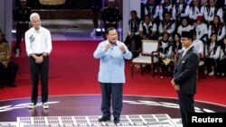 Dari kiri; Ganjar Pranowo, capres dari PDI-P, Menteri Pertahanan Indonesia dan capres Prabowo Subianto, dan capres Anies Baswedan dalam Debat Capres RI di kantor KPU di Jakarta, 12 Desember 2023. (REUTERS/Ajeng Dinar Ulfiana)