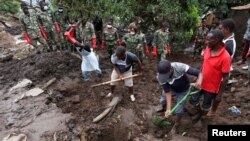 FILE - Members of the community and the Malawian army recover victims' bodies in Chimwankhunda township in the aftermath of Cyclone Freddy in Blantyre, Malawi, March 17, 2023. 