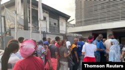 Sejumlah warga Nigeria mengantre di depan sebuah bank di Lagos, Nigeria, pada 6 Februari 2023. (Foto: Thomson Reuters Foundation/Bukola Adebayo)