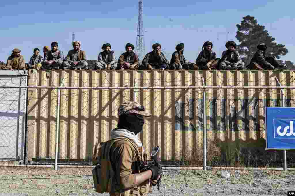 Taliban security workers watch Afghan horsemen compete in a traditional Central Asian sport, buzkashi, during a friendly match between provinces at a field in Kabul.