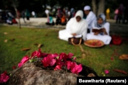 Sebuah keluarga berdoa di dekat bunga di kuburan massal tsunami di Banda Aceh, 26 Desember 2014, sebagai ilustrasi. (Foto: Reuters/Beawiharta)