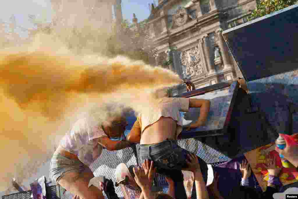 A police officer sprays an irritant smoke at demonstrators during a protest to mark International Women's Day in front of Mexico's National Palace in Mexico City, Mexico, March 8, 2023.