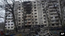 A destroyed car is seen in the yard of kindergarten after a Russian rocket attack in Kyiv, Ukraine, Dec. 13, 2023. Ukraine is working to boost its defense industry at home by signing contracts for joint cooperation on technology weapons production with Western partners. 