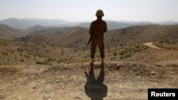 FILE - A soldier stands guard outside the Kitton outpost along the border fence on the border with Afghanistan in North Waziristan, Pakistan, on Oct. 18, 2017.