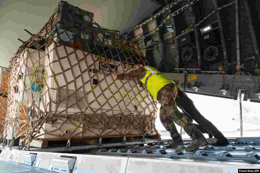 In this photo provided bye the French Army, soldiers load a cargo plane with disaster relief for Libya, Sept. 13, 2023, at the Istres military base, southern France.