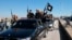 FILE - IS militants are seen in Tel Abyad, Syria, May 4, 2015. There are concerns about an upswing in Islamic State attacks across Syria, though the United States has expressed skepticism about their significance. (Militant website via AP)