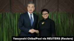 Menteri Luar Negeri China Wang Yi dan Menteri Luar Negeri Retno Marsudi berjabat tangan saat bertemu di Jakarta, 18 April 2024. (Foto: Yasuyoshi Chiba/Pool via REUTERS)