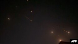This video grab from AFPTV taken on April 14, 2024 shows explosions lighting up the sky in Hebron in the Israeli-occupied West Bank during an Iranian attack on Israel. 