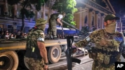 러시아 바그너 그룹 용병들이 24일 밤 러시아 로스토프에서 탱크를 트럭에 싣는 작업을 지키고 있다.