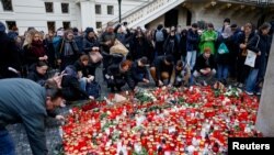 21일 총기 난사가 발생한 체코 프라하 카렐대학교 내 추모장소에 다음날(22일) 방문객들이 초를 놓고 있다.