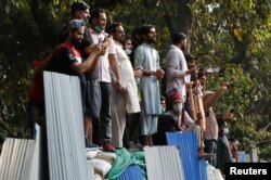 Supporters Imran Khan are seen outside his home after police postpone his arrest, in Lahore, March 15, 2023.