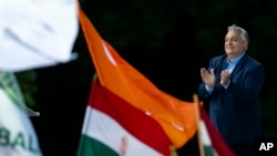 Hungary's Prime Minister Viktor Orbán addresses people as they gather to support him and his party during a 'peace march' in Budapest, Hungary, June 1, 2024.