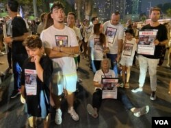 原本在广场上与群众一起等待会议报告的人质家属逐渐失去耐心、开始发声抗议，由广场转移阵地到街道上中断交通。当警察尝试恢复交通秩序，一位人质（Jonathan Samerano）的祖母干脆坐在街道上、手拿孙子的海报、带领群众呐喊“现在就交换他们”。(美国之音/赖素芬)