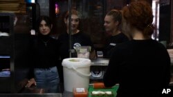 The workers of White Burger restaurant wait to take orders, in Kramatorsk, Ukraine, Sept. 13, 2023.